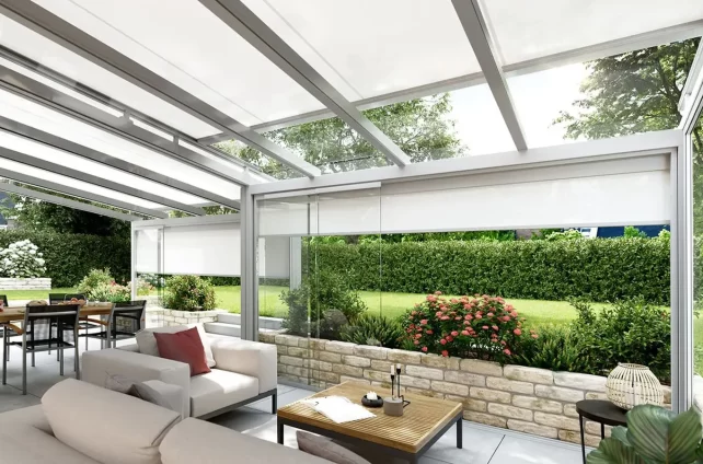 Moderne serre met glazen wanden, uitschuifbare zonwering en groen uitzicht
