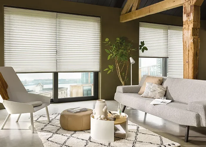 Landelijk interieur met een wit bankstel, ronde houten tafels en gebroken witte plissegordijnen