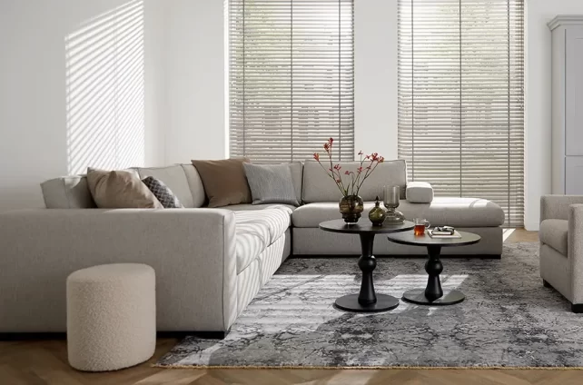 Lichte woonkamer met grote ramen en stijlvolle houten jaloezieën.