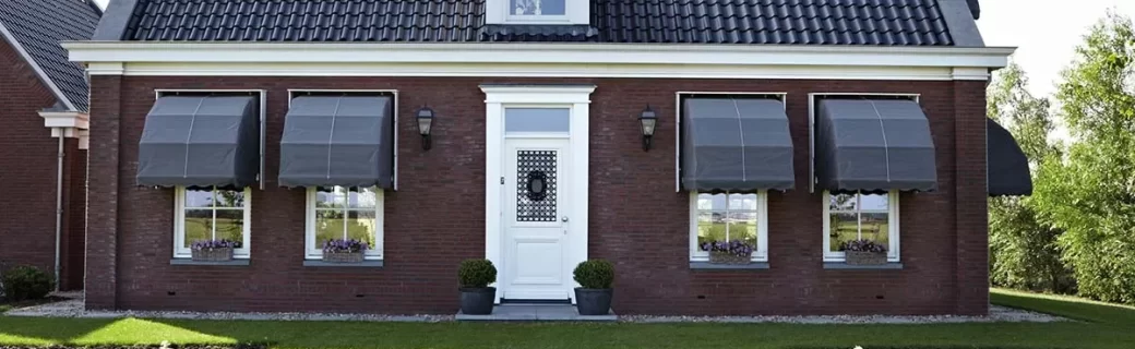 Traditioneel huis met zwarte markiezen, stijlvolle zonwering voor een klassieke uitstraling