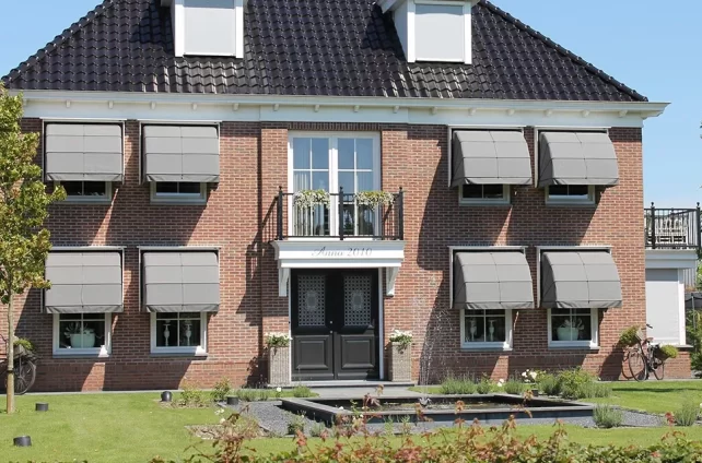 Klassiek herenhuis met stijlvolle markiezen als zonwering voor de ramen