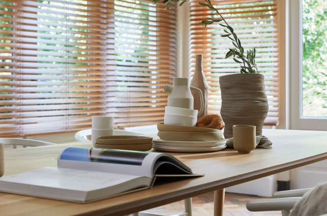 Houten jaloezieën in een lichte, natuurlijke eetkamer