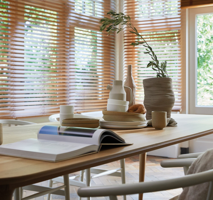 Houten jaloezieën in een lichte, natuurlijke eetkamer