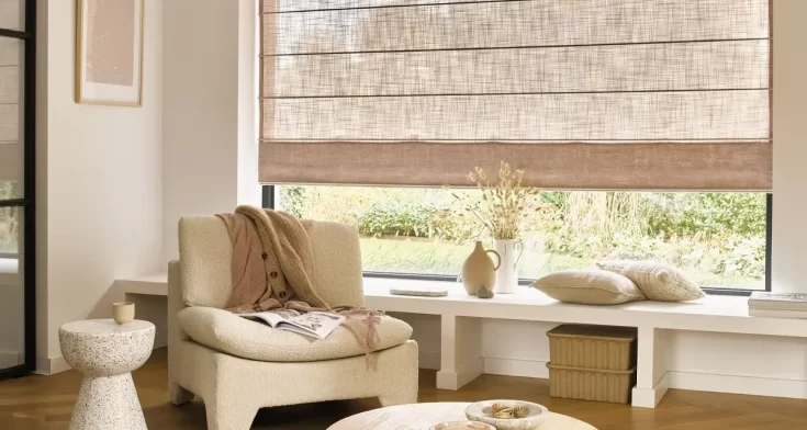 Zithoek met beige meubels en beige vouwgordijnen voor de ramen