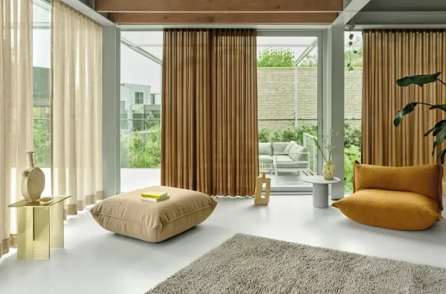 Ruime lichtgekleurde woonkamer met twee kleuren lichtdoorlatende gordijnen