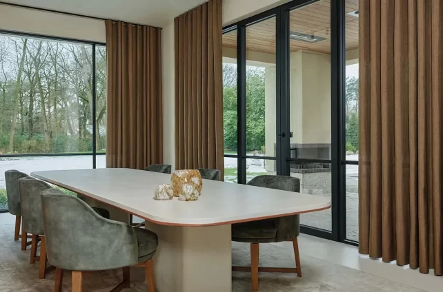 Ruime eetkamer met neutrale tinten en bruine gordijnen
