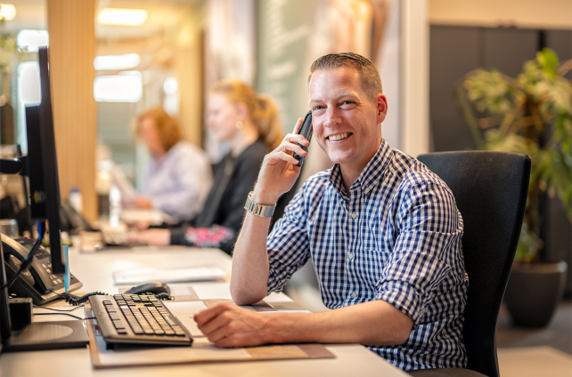 Klantenservicemedewerker van Deventer Zonwering aan de telefoon op kantoor