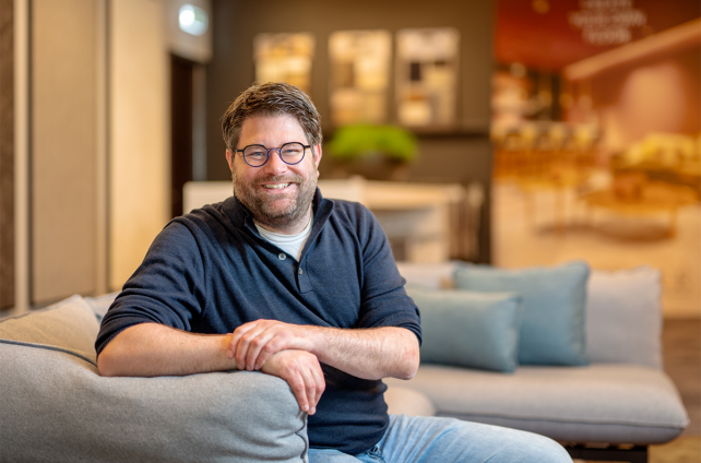 Eigenaar van Deventer Zonwering zit ontspannen op een bank in de showroom
